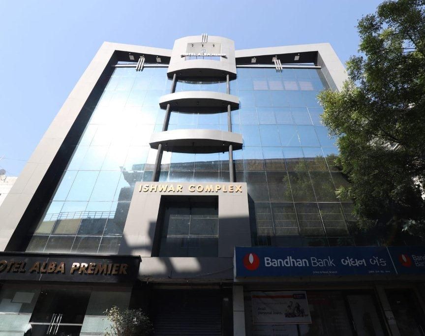 A bright facade of Pravasa Stay, Ahmedabad (Alba Premier), taken on a sunny day with a clear blu sky in the background.