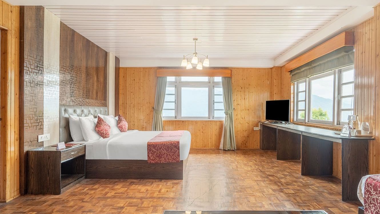 Side view of a room with bed and wooden wall decor at Summit Tashi Ghang Heritage Resort, Pelling