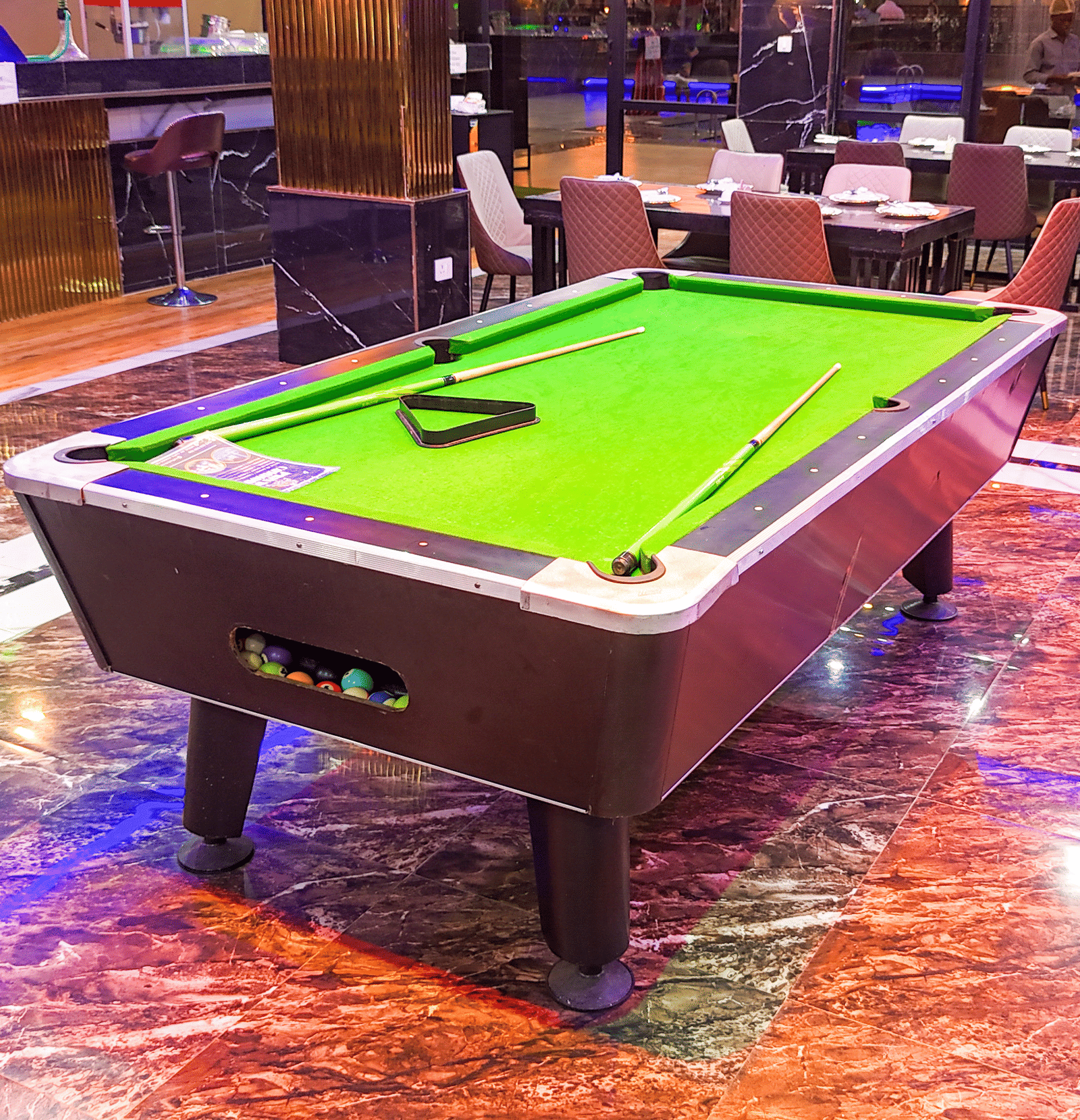 Interior view of a lounge area with a small pool table - Luffu Club