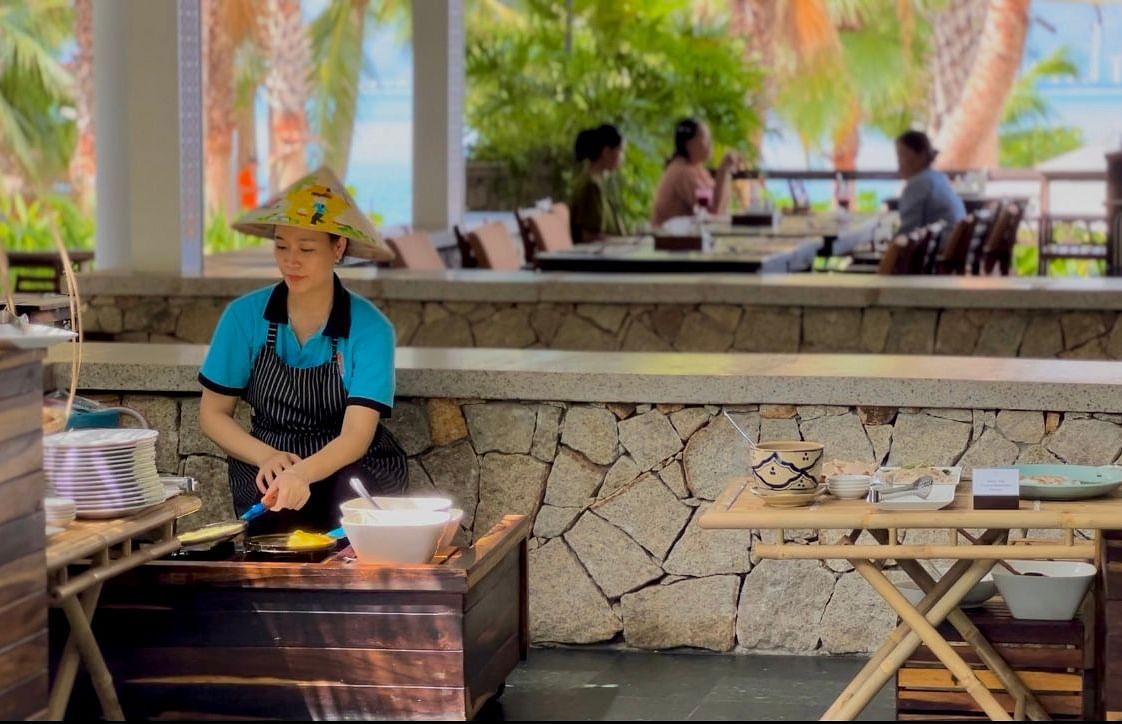 An image of a woman cooking at a restaurant - Alibu Resort Nha Thrang