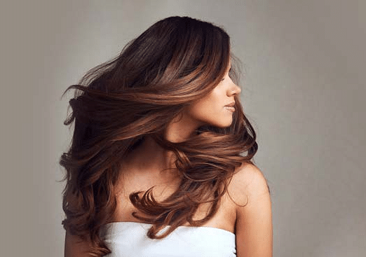 Woman showcasing smooth, voluminous, professionally styled hair.
