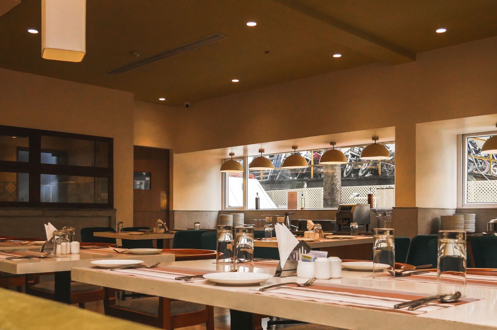 An inviting restaurant interior with neatly set tables and elegant lighting, ready for diners at Shilton Dee Cee.