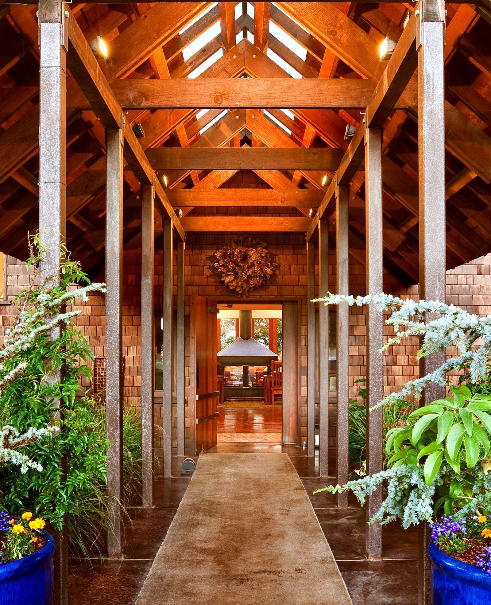 The rustic, wooden entrance to our Inn surrounded by greenery and illuminated by natural light - Brewery Gulch Inn & Spa