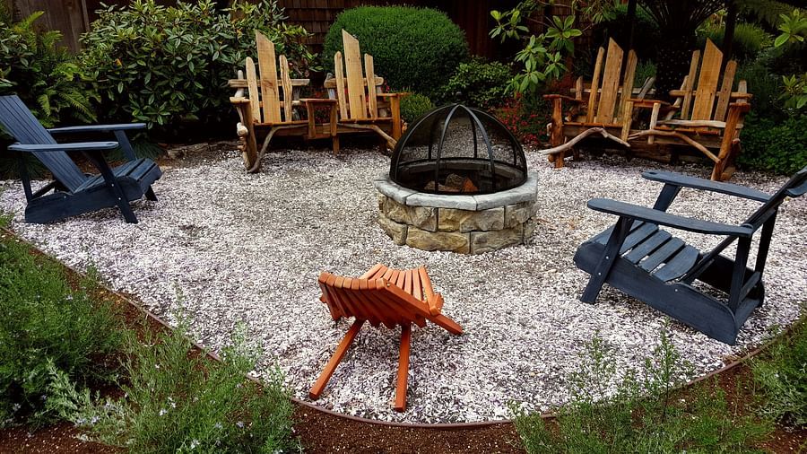 A cozy outdoor fire pit with wooden chairs around it - Brewery Gulch Inn & Spa