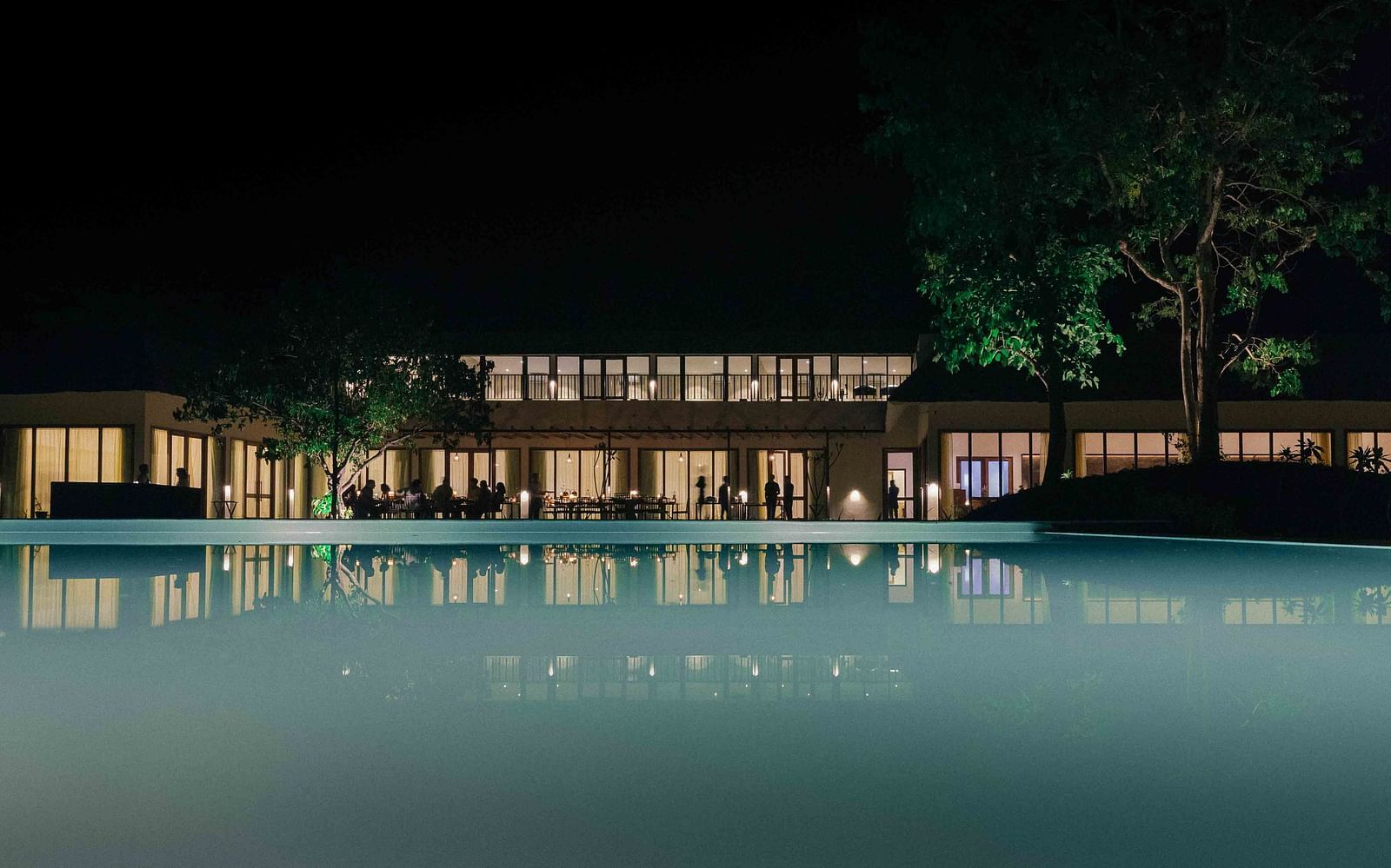 facade of Saraca Corbett with a pool in front of it during night time