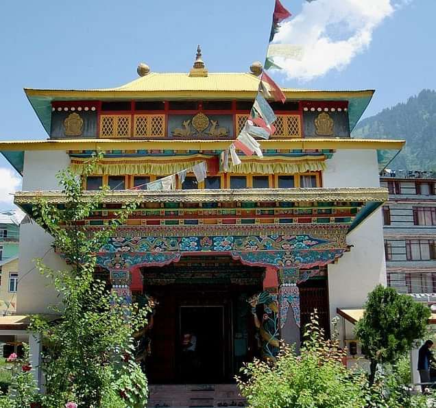 Image of a Tibetian Monastery with prayer flags tied to it.