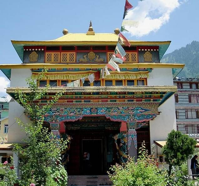 Image of a Tibetian Monastery with prayer flags tied to it.