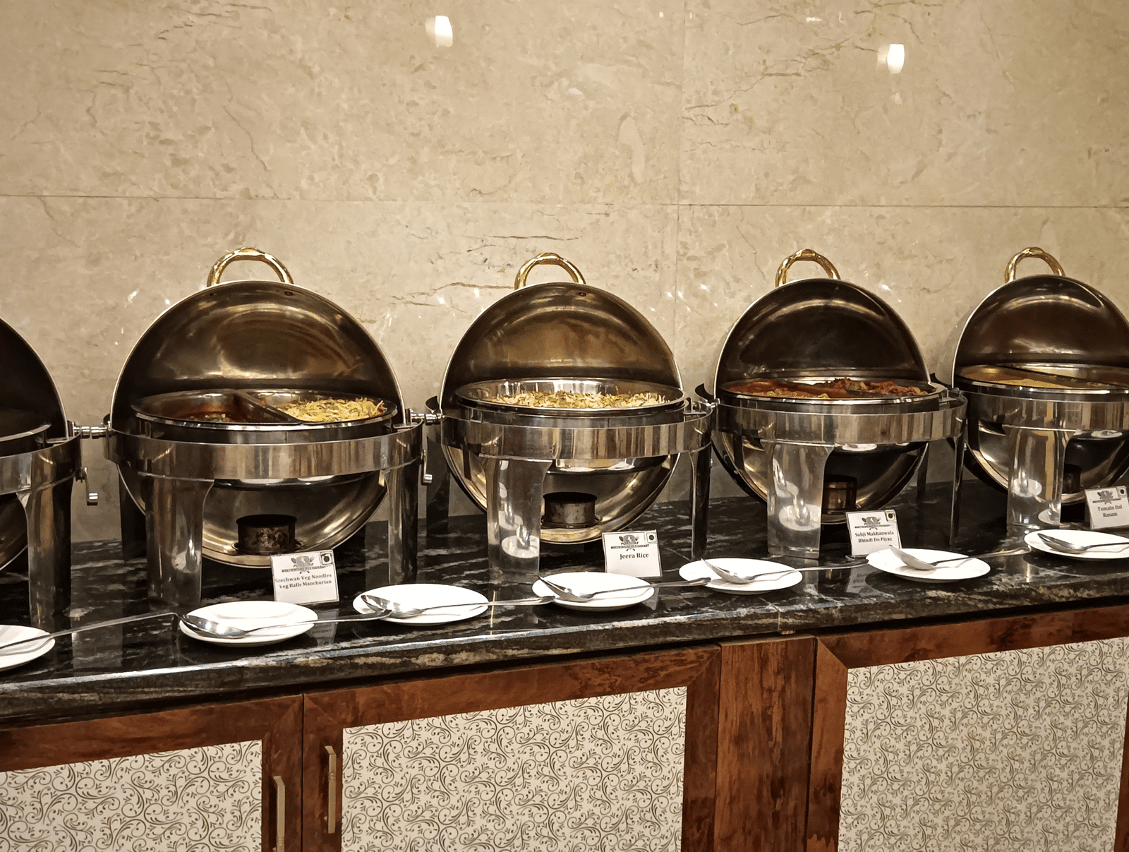 A buffet counter with gleaming chafing dishes arranged for a delectable multi-cuisine dining spread - Benzz Park, Kodaikanal