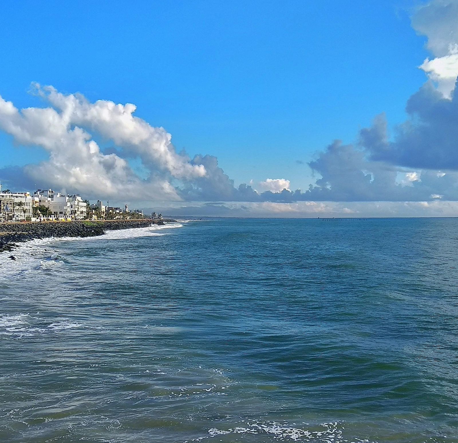An overview of promenade beach with clouds hovering over the waterbody