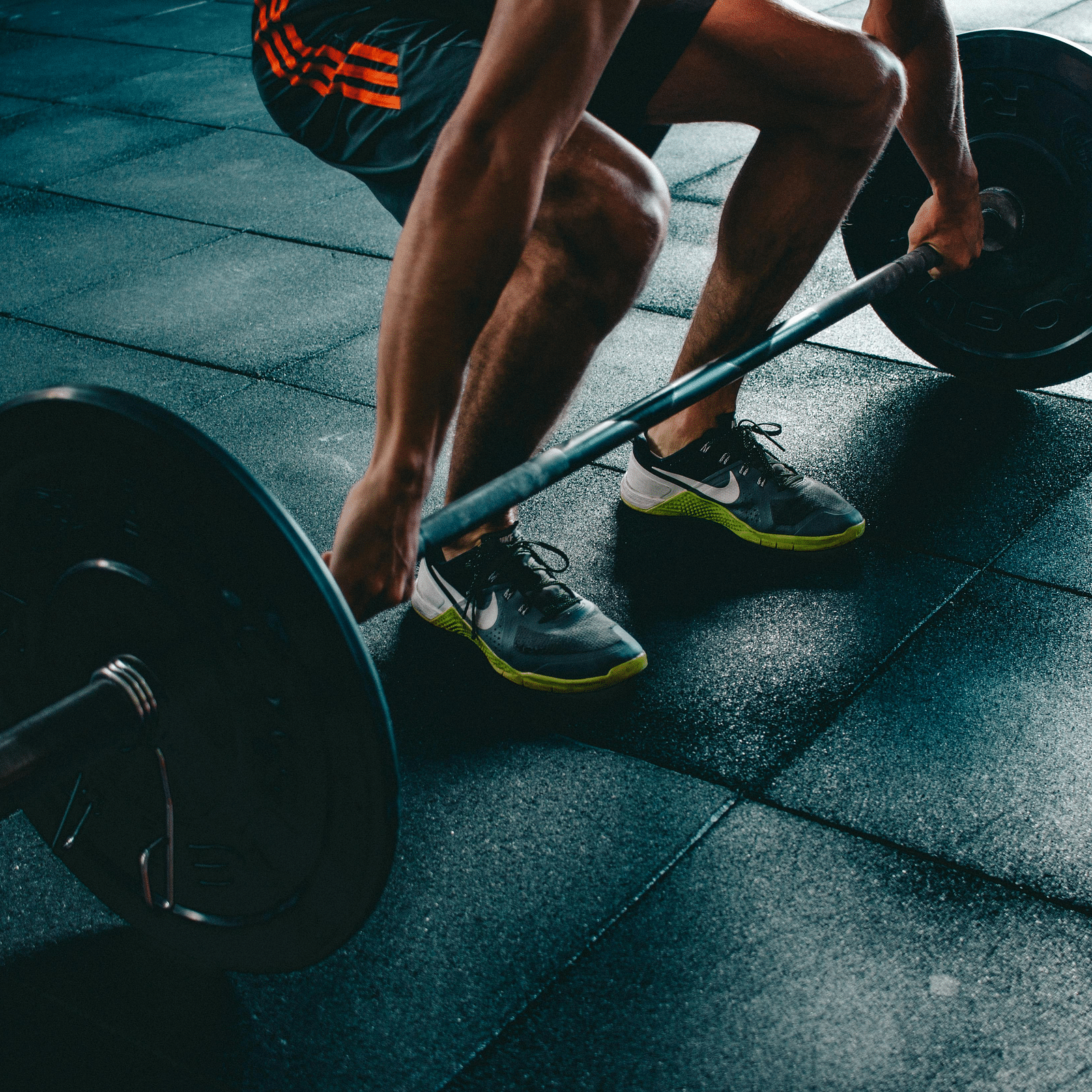 A person preparing to lift a barbell in the gym