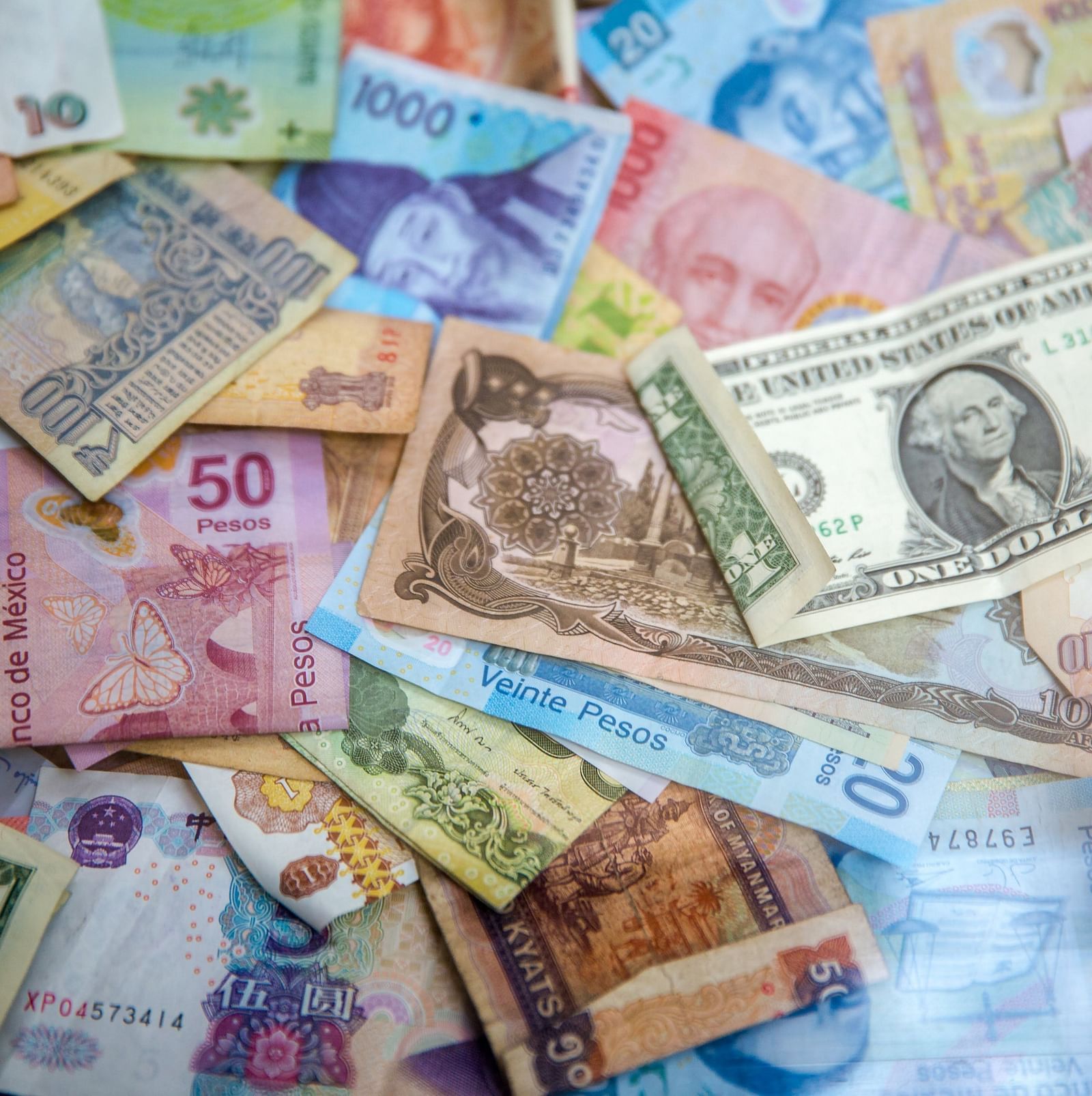 A collection of various international banknotes scattered in disarray.