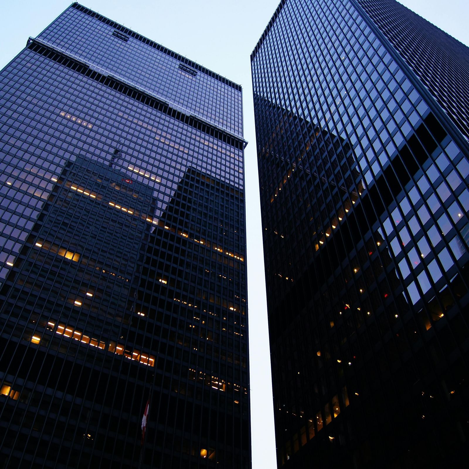 Low angle view of modern skyscrapers in a city against a blue sky.