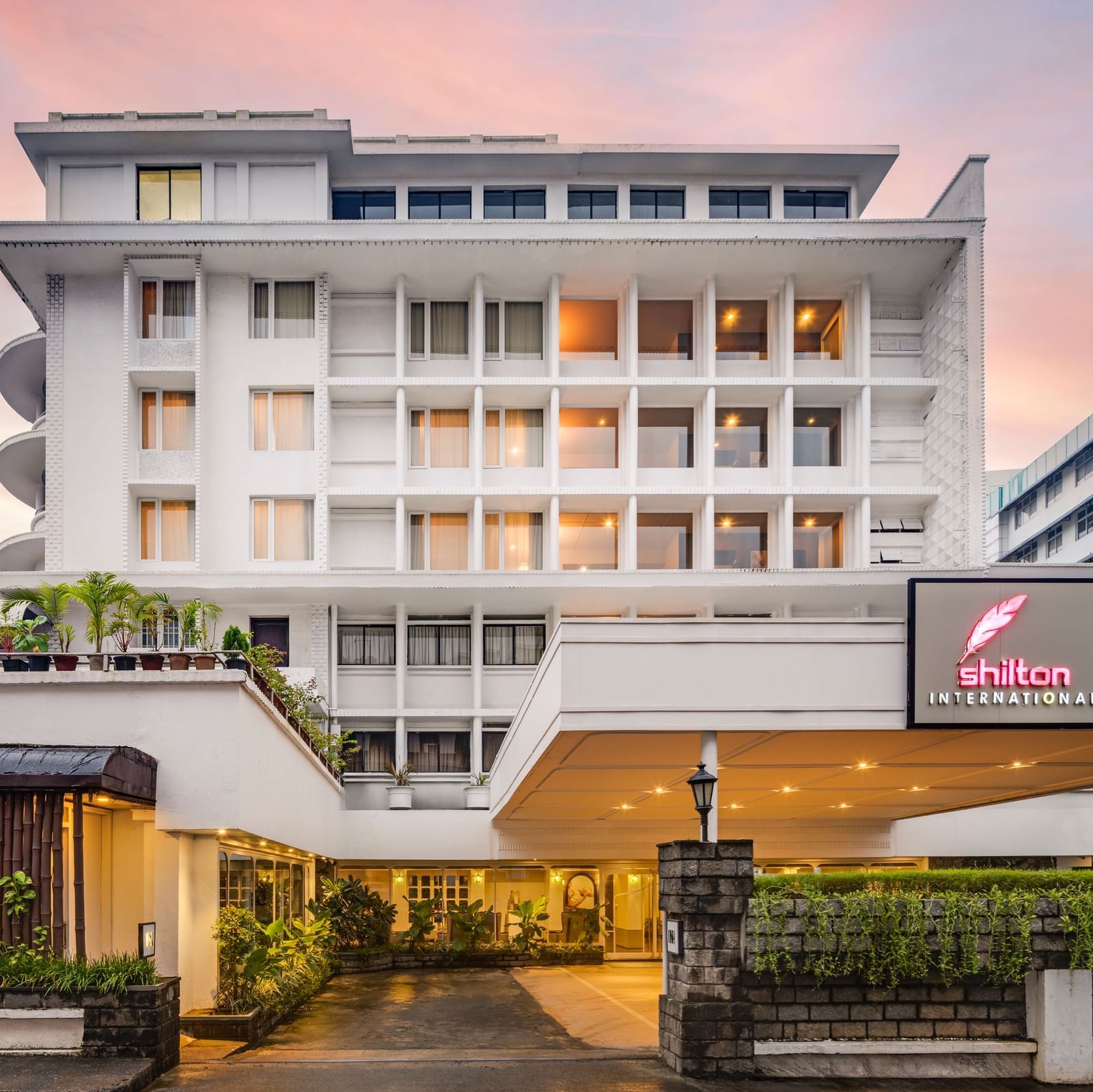 A grand multi-storey edifice with a BAR sign and a Shilton International, Kochi, sign, offering accommodation.