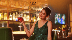 An image of a woman sitting at the bar and holding a glass of wine -  Hotel Polo Towers, Agartala