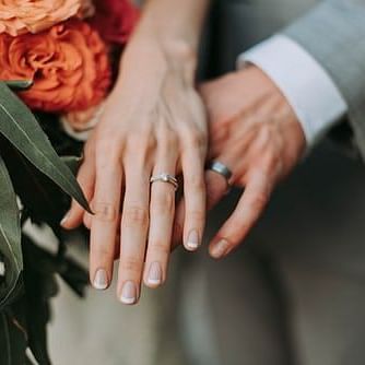 bride and groom showing off their rings
