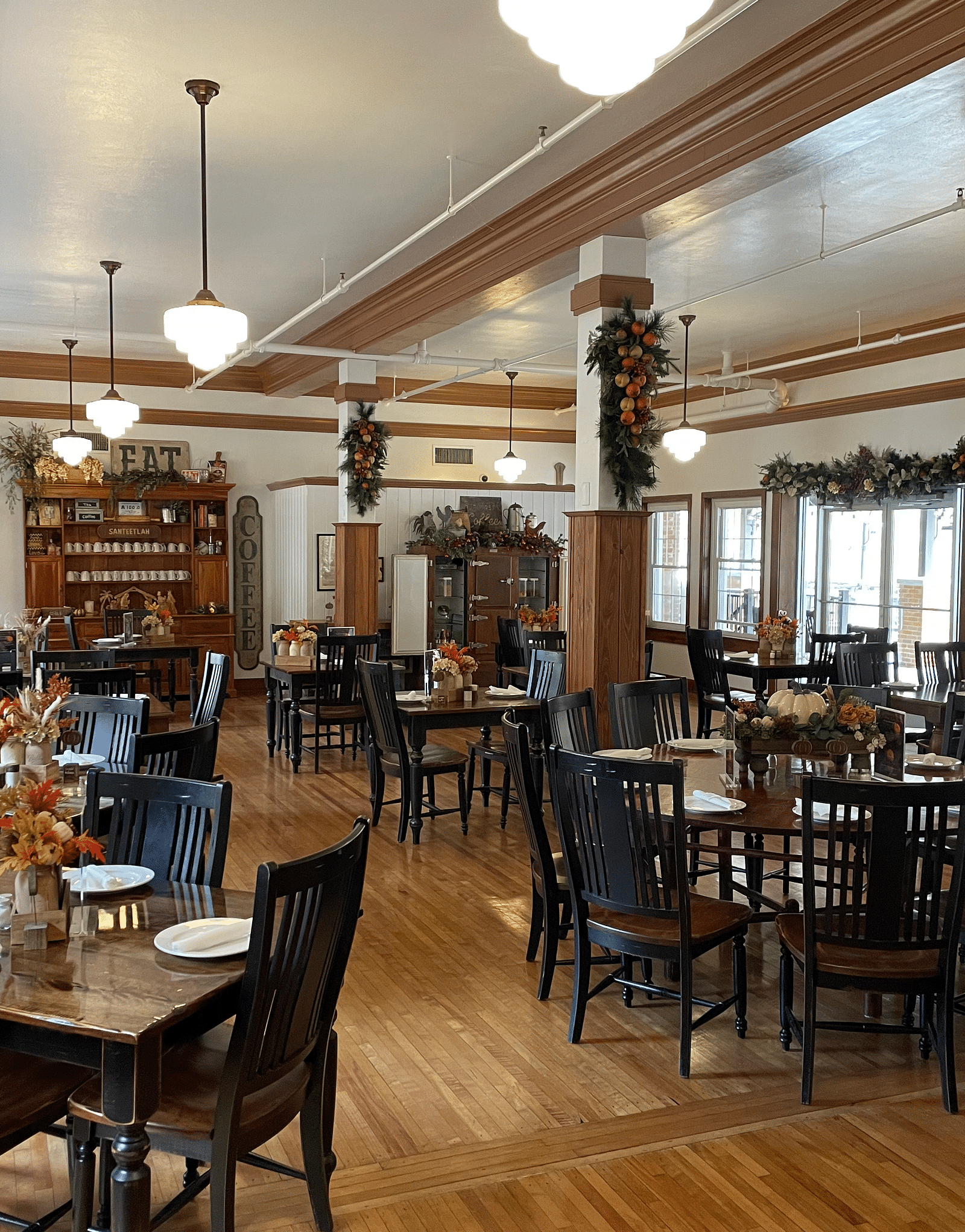 full view image of the Cheoah Dining Room with dark brown colored chairs and tables decorated with well placed cutlery - Historic Tapoco Lodge