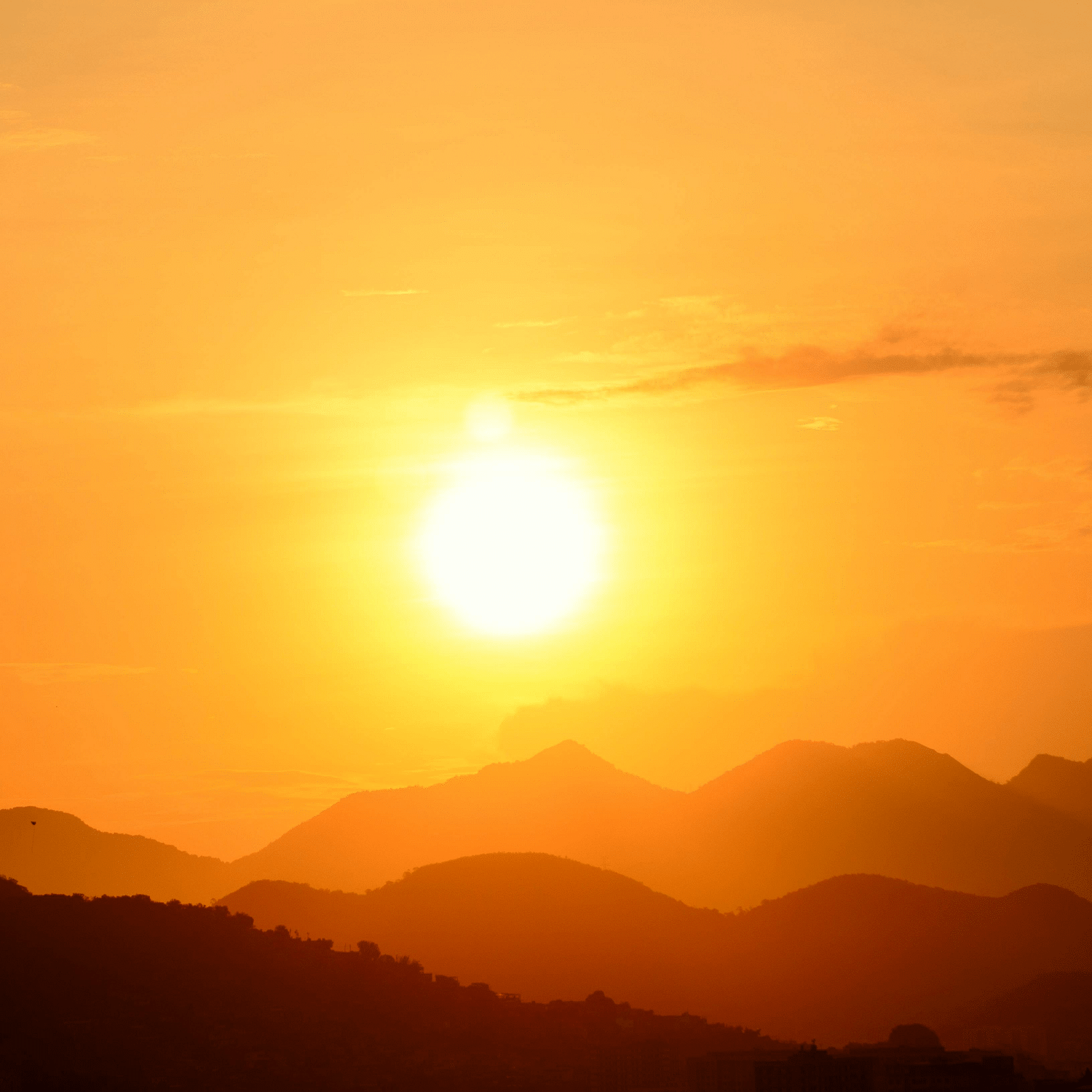Sun just right over the hills making a silhouette and the light creating a golden hue in the  sky