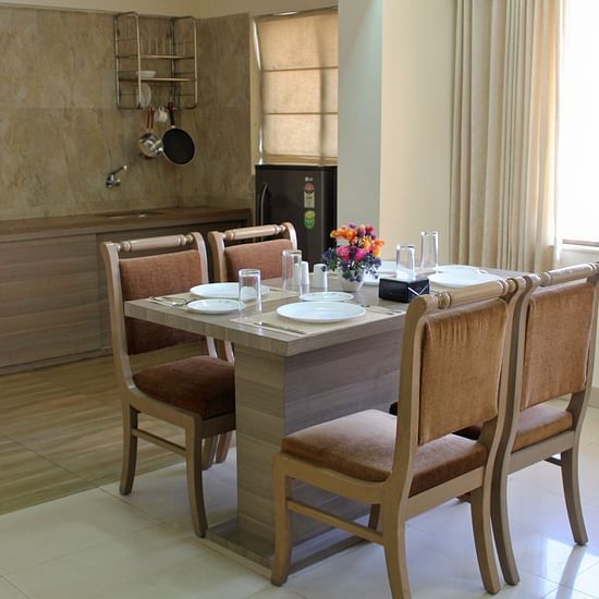 A back view of a rectangular dining table with four brown chairs around it