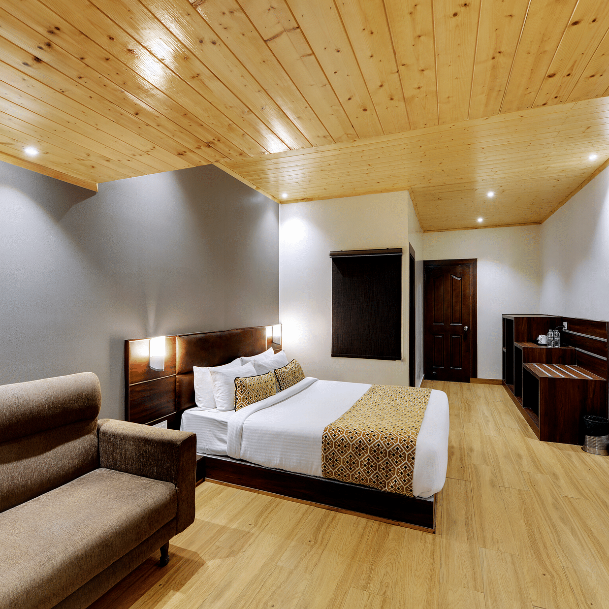 Side view of a double bed and a sofa in the Executive Deluxe Room at Hotel Sumitel Vista T.V Tower