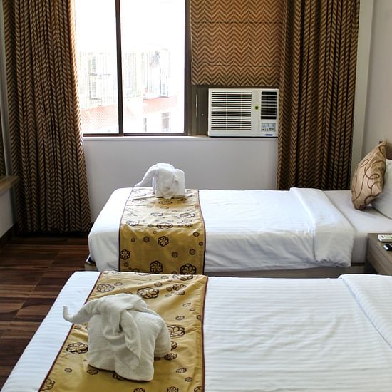 A room featuring two twin beds a mini bar and a TV - Maxxvalue Apartment Marol