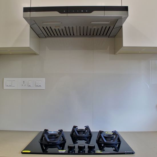 Kitchen of a flat featuring a chimney and a stove - Maxxvalue Apartment Hiranandani Powai