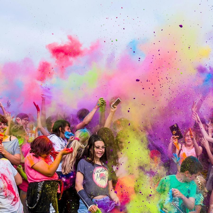 People in groups playing holi - a colourful festival in celebrated in India with coloured powders.