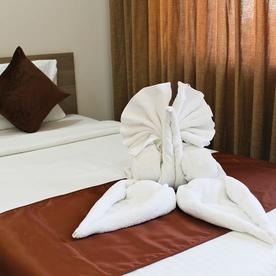 A room featuring a decorated bed and pillows - Maxxvalue Apartment Marol