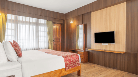 Image of a room with bed and television in front at at Summit Tashi Ghang Heritage Resort, Pelling