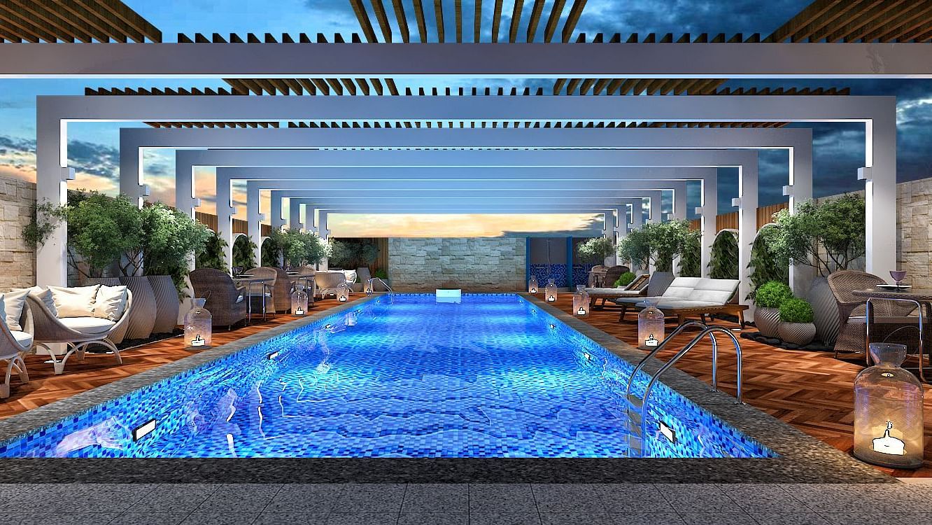 An overview of the swimming pool at kertel suites, kinshasa with sun loungers next to it.