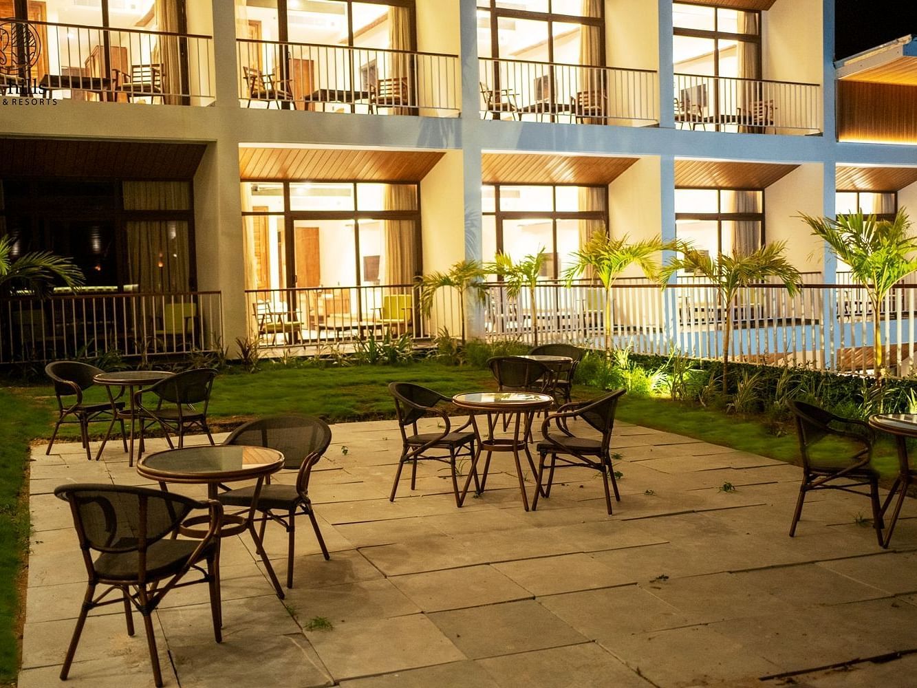 An outdoor seating area with tables and chairs on a paved patio in front of a hotel building - Sea Hills Resort, Swaraj Dweep (Havelock)