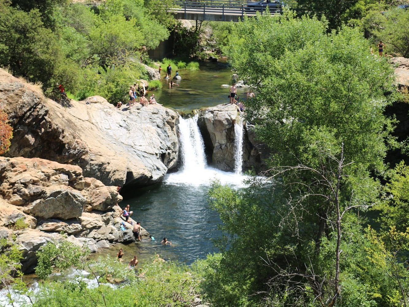 Aerial view of Rainbow Pools, featuring stunning waterfalls surrounded by lush greenery and natural rock formations