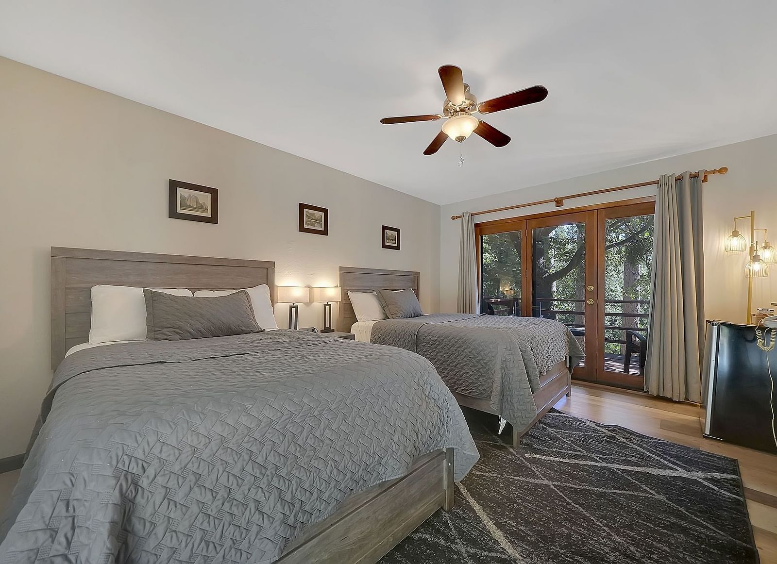 A room at Narrow Gauge Inn with twin beds and a balcony with seating.