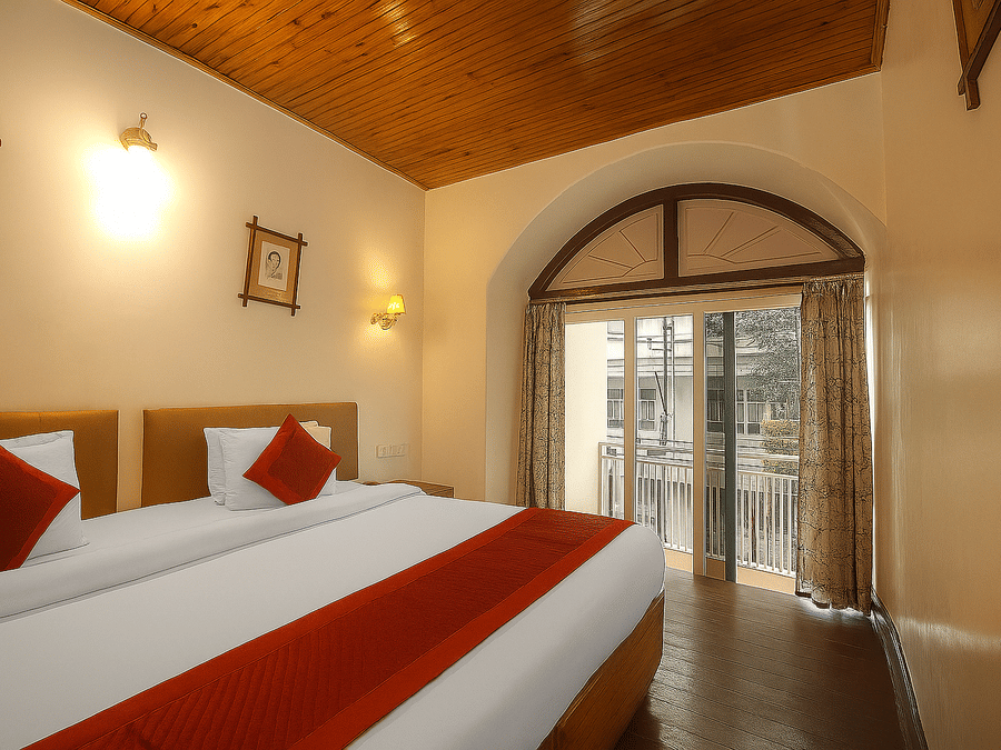 A room at Central Hotels featuring two beds with red and white bedding wooden ceiling an arched doorway leading to a balcony with warm wall lighting and dark hardwood flooring.