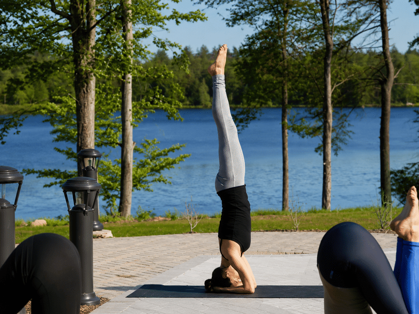 A group of people practicing yoga on a sunny patio at YO1 Longevity and Health Resorts