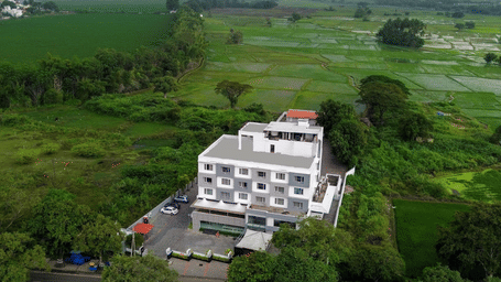 Aerial view of the hotel featuring a multi-storey building placed amidst lush greenery | Regency Palani by GRT Hotels