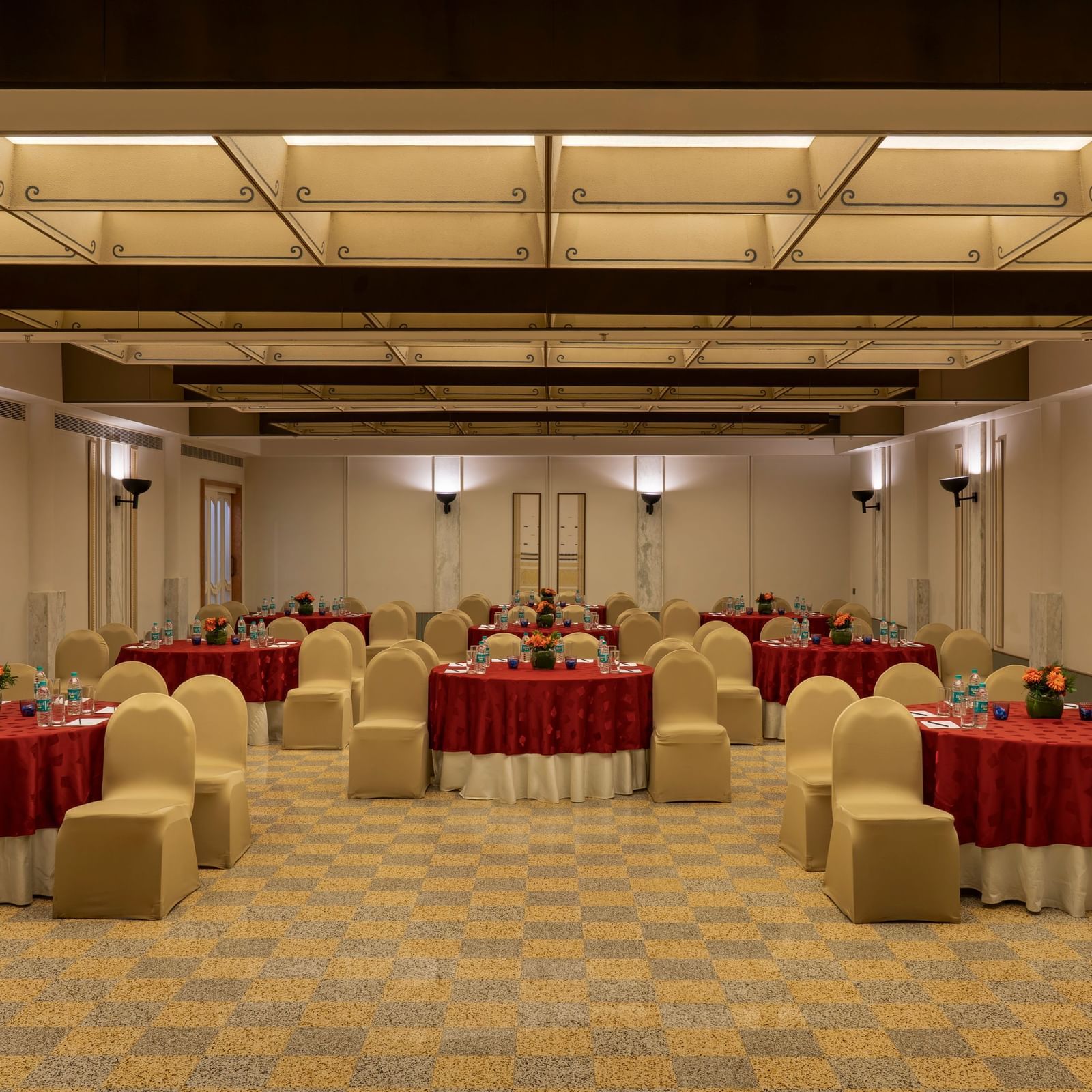  A banquet hall at Shilton International, Kochi, set with round tables and chairs for a gathering.