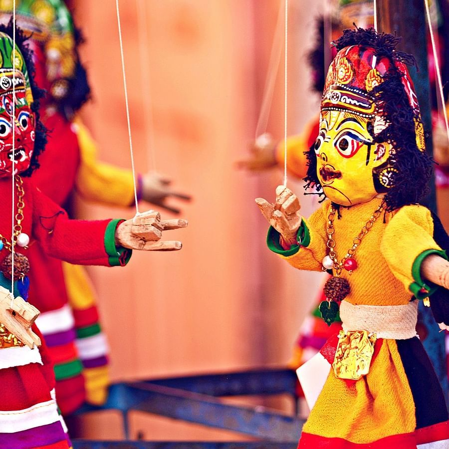 two puppets being controlled by a puppet master during a puppet show