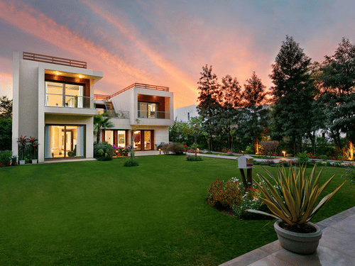 exterior facade of one of the villas with a manicured garden in front of it at Karma Lakelands.