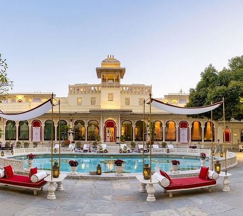 A facade image of Shiv Niwas Palace with a pool in front