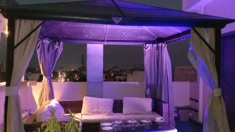 A luxurious outdoor dining setup with purple ambient lighting and elegant canopy seating at the best restaurant in Banaras - Hotel Uday Palace.