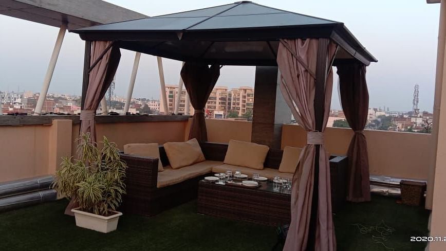 A hut-style top covering an open-space sofa setting at Hotel Uday Palace.