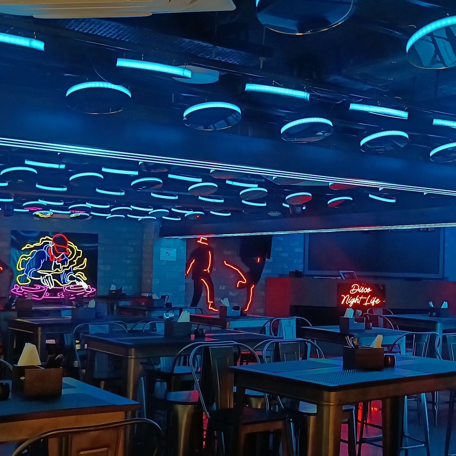 Disco Night Life dining area at Wonder Country Club and Resort, Kharagpur showcasing elegant neon lighting, stylish decor, and well-arranged tables