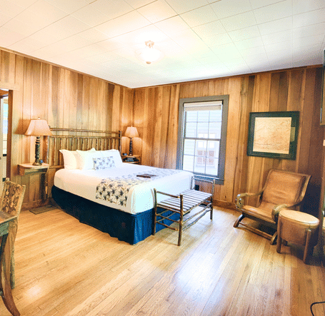 full vie image of the room with a blend of modern and vintage furniture featuring a writing desk and chair in the room - Historic Tapoco Lodge