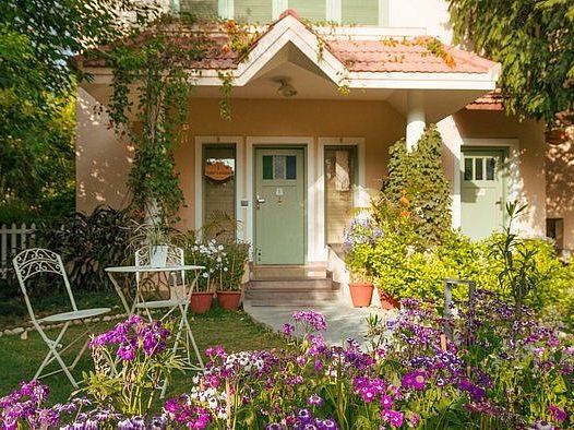 Small house-style building with chairs and flowers outside at Karma Chalets.