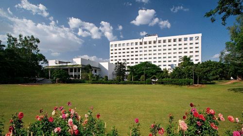 A panorama of the facade and the green lawn in the foreground at Hotel Clarks Amer, the best hotel in Jaipur near the airport.