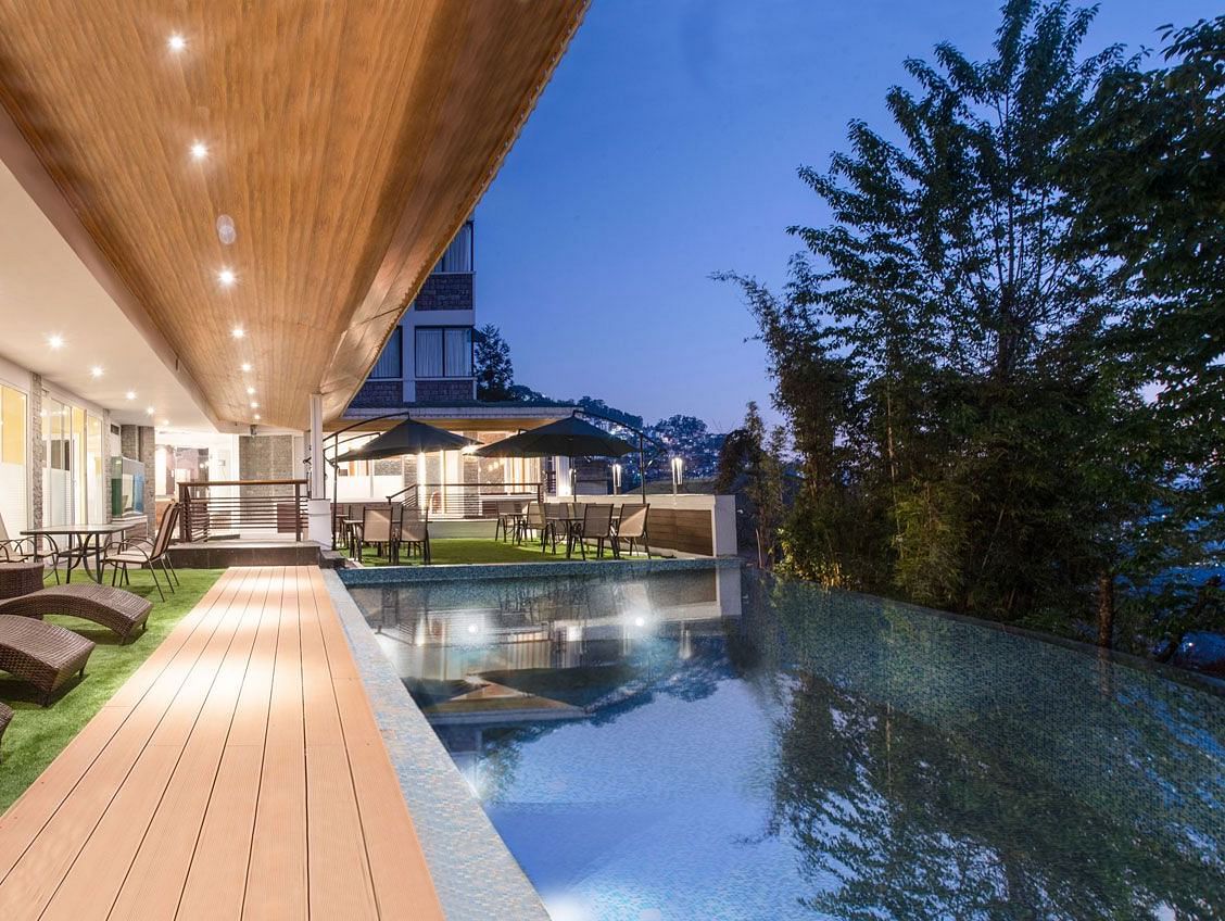 A night time view of a pool with sun loungers placed on its deck - Summit North Star, Gangtok