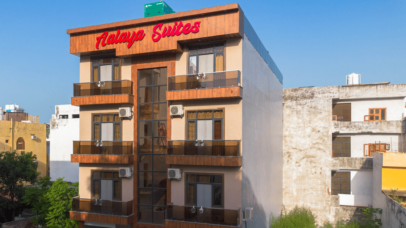 Exterior view of the multi-storey hotel building with 'Aalaya Suites' written on top under a bright blue sky - Perfectstayz Value Aalaya Suites, Haridwar
