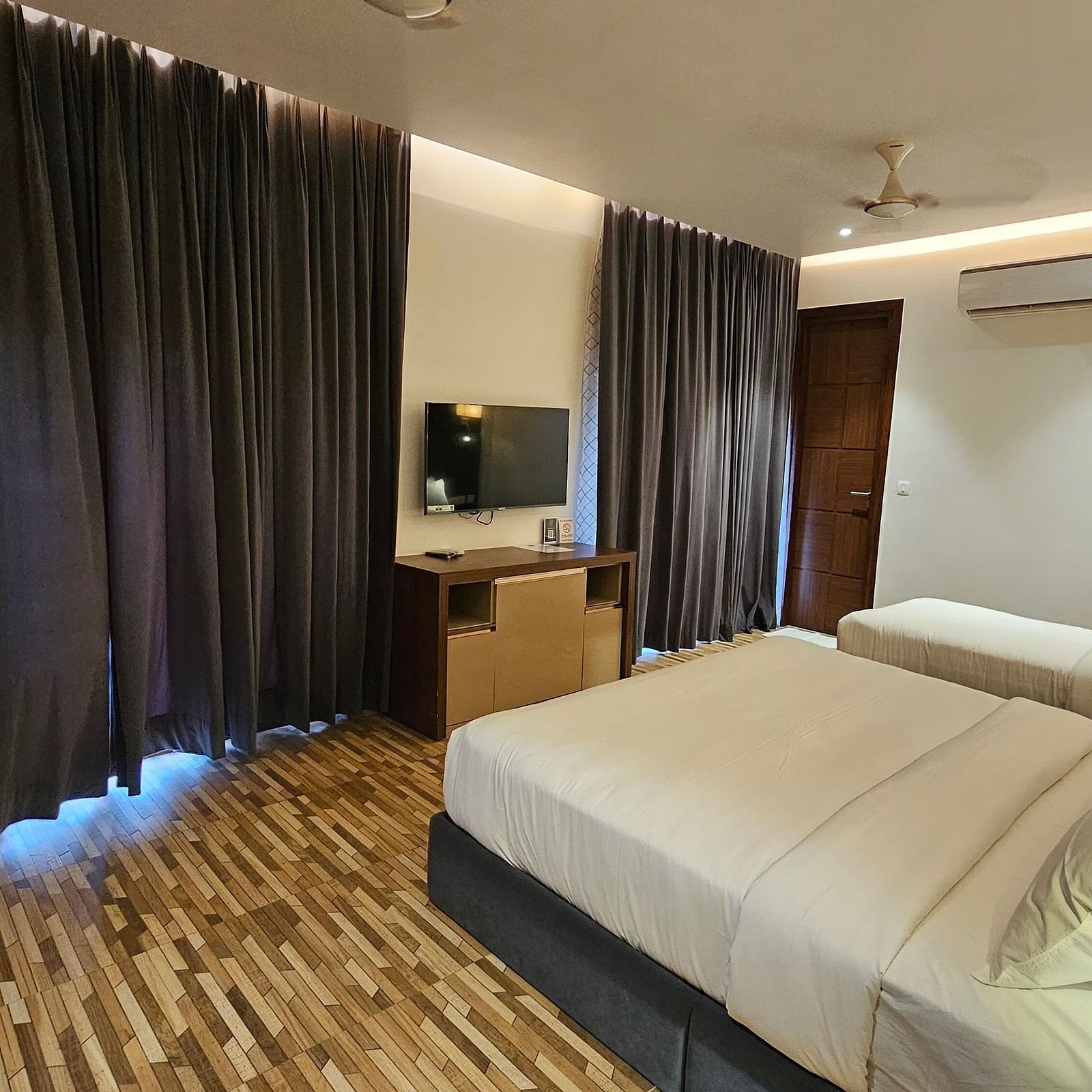 a family executive room at Eminence The Corbett with curtains drawn over the windows