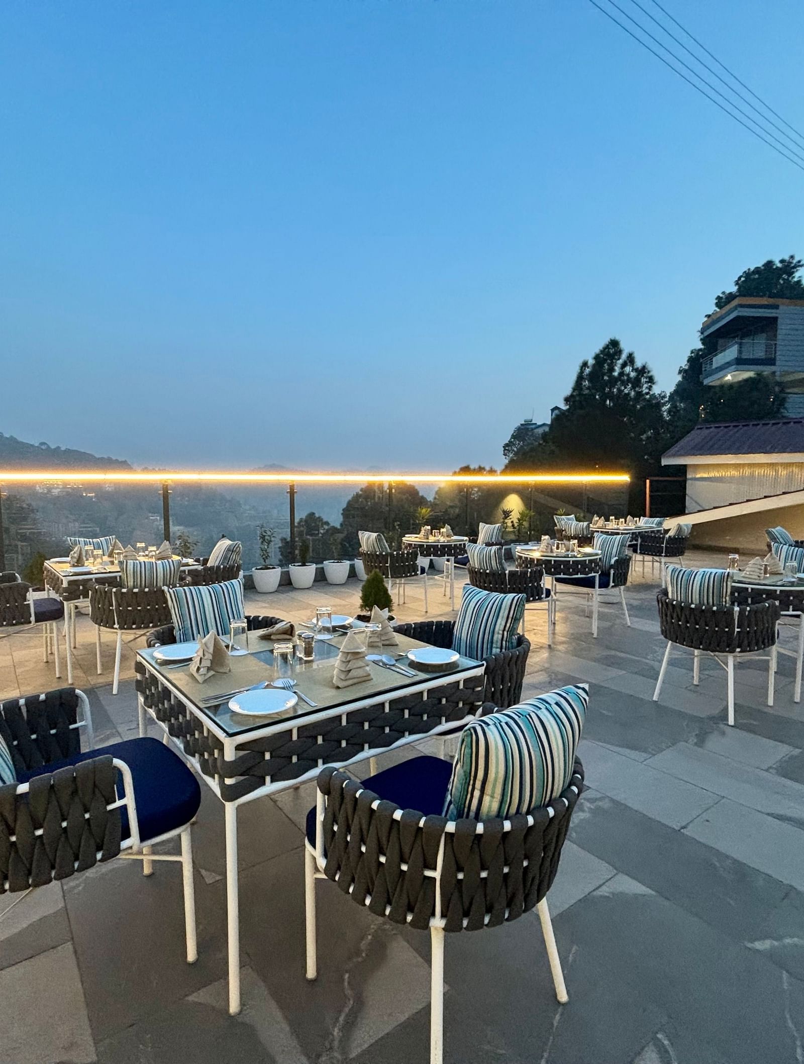 Outdoor dining area at twilight with neatly arranged tables and scenic views – ARNISA Boutique Hotel