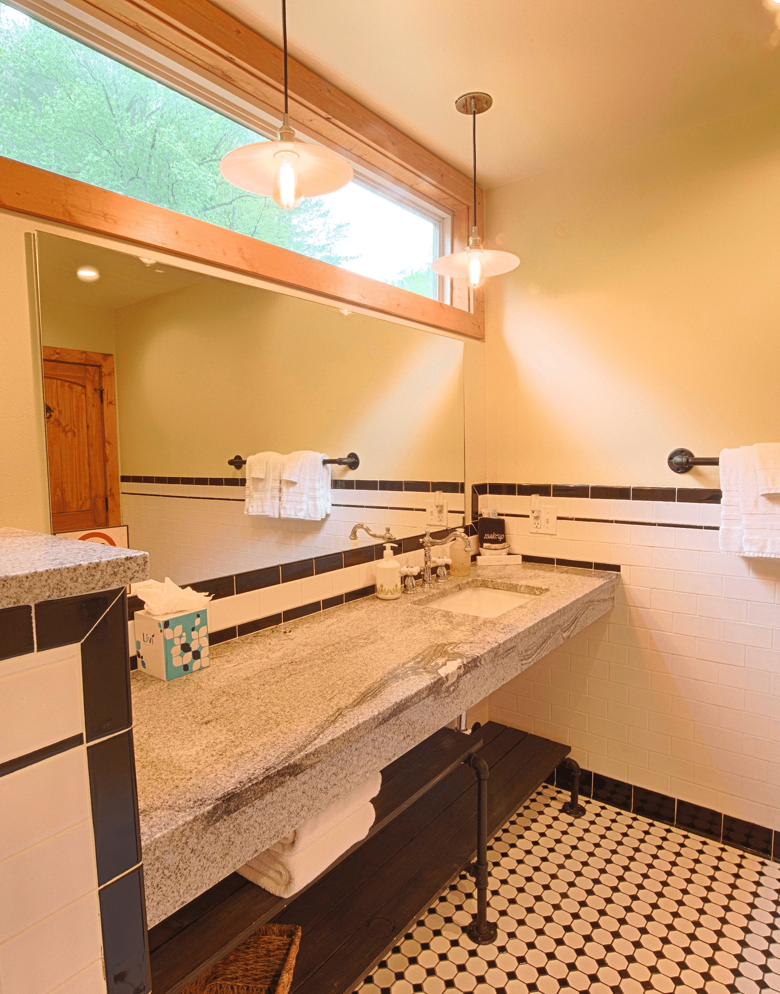 the washbasin with a wide mirror being featured in a bathroom along with a narrow window above it throwing natural light - Historic Tapoco Lodge
